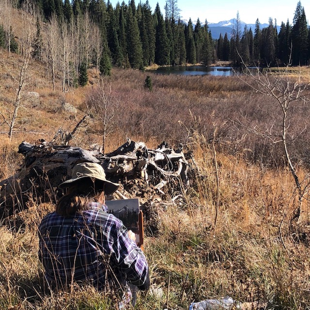 Painting a mountain pond plein air.