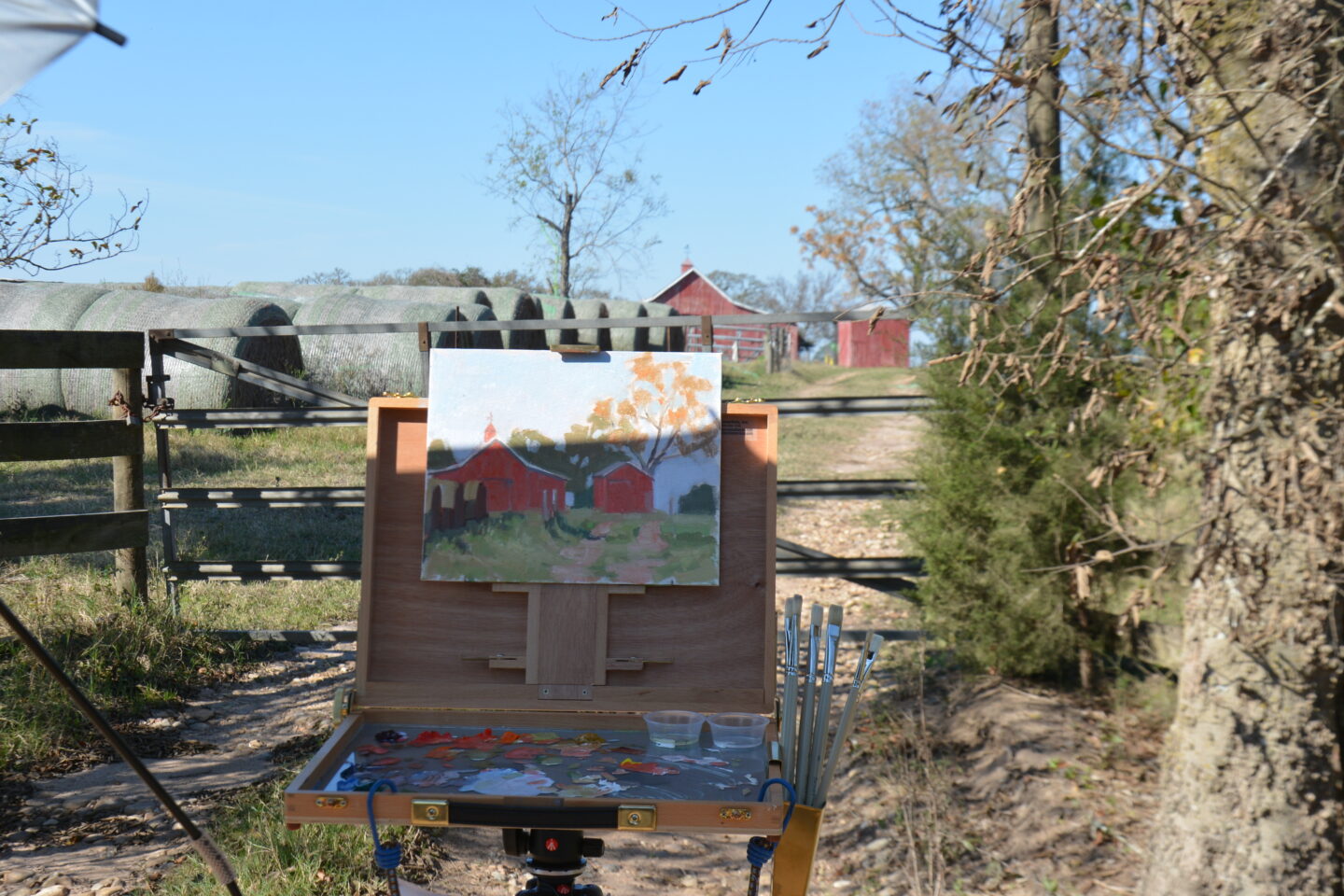 Plein air painting a red barn.